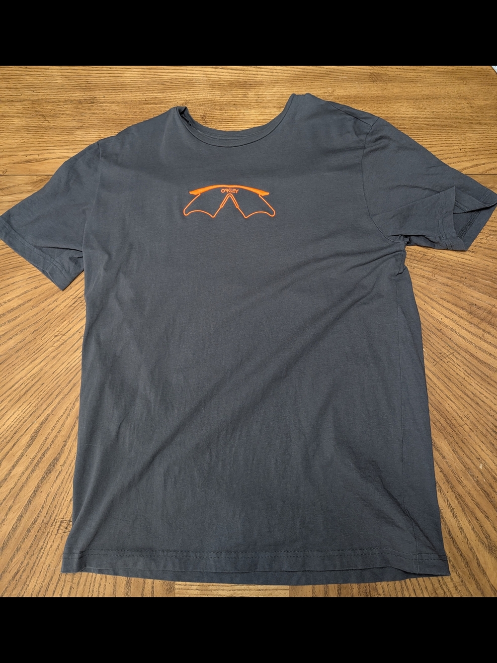 Oakley Short Sleeve Tee in Charcoal with Orange Graphic.